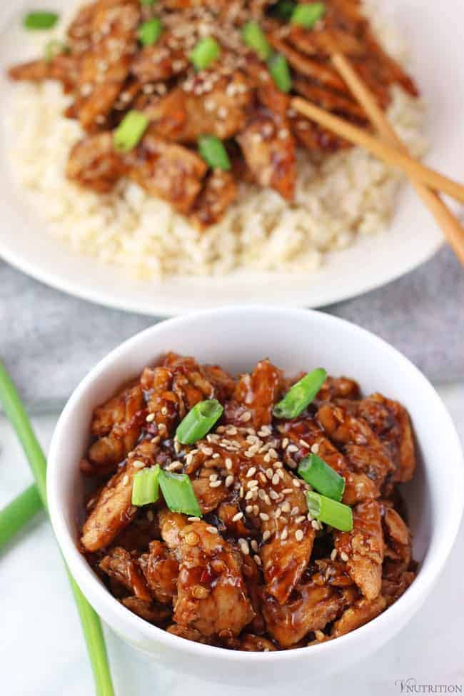 vegan Mongolian beef in a small white bowl topped with sesame seeds and green onions
