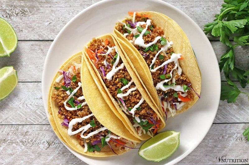 Walnut Meat Tacos on a white plate with a wedge of lime for serving.