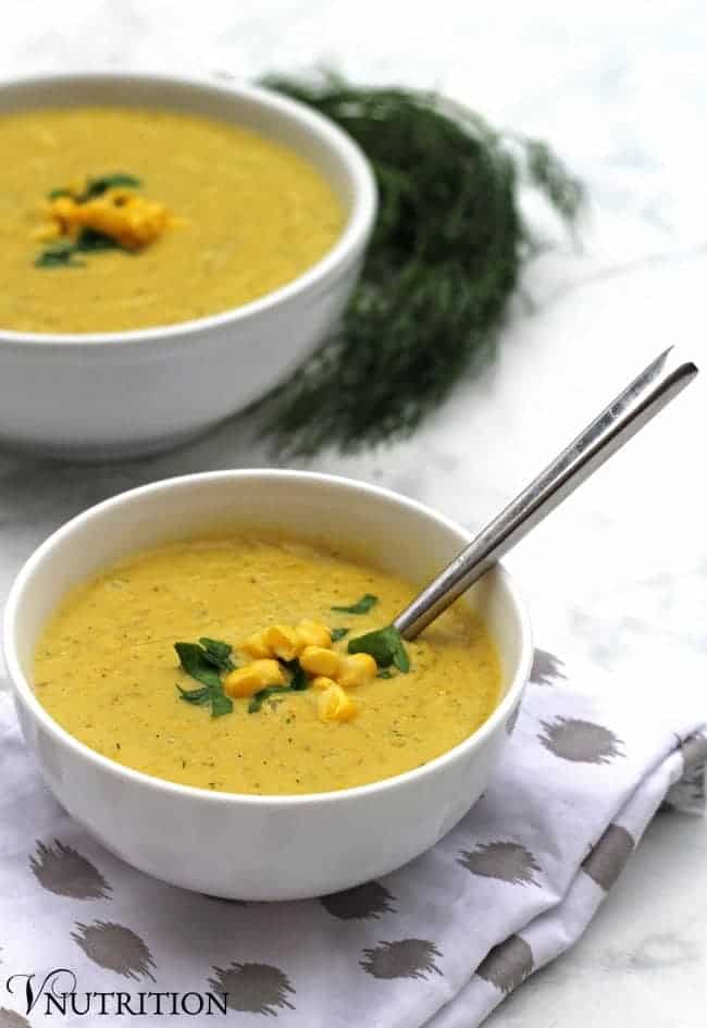 bowl of Creamy Vegan Corn Chowder with a silver spoon sticking out.