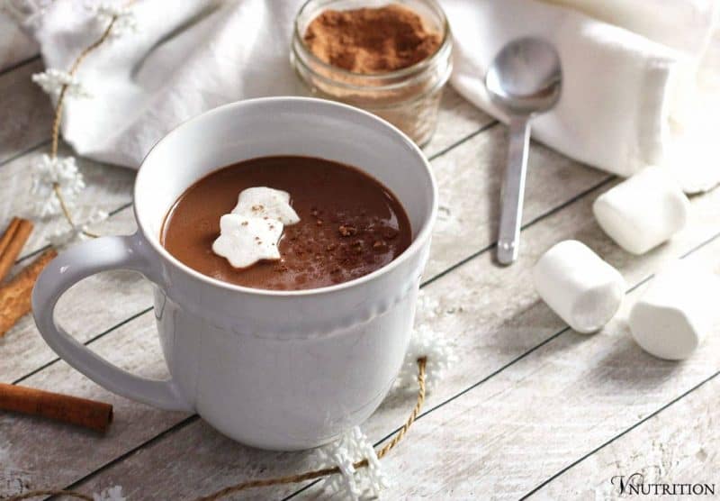 vegan Gingerbread Hot Chocolate garnished with star shaped marshmallows and a sprinkling of cinnamon.