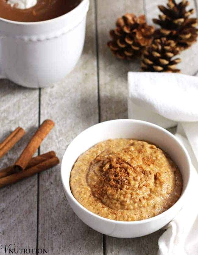 snickerdoodle hummus in white bowl with coffee in the background.