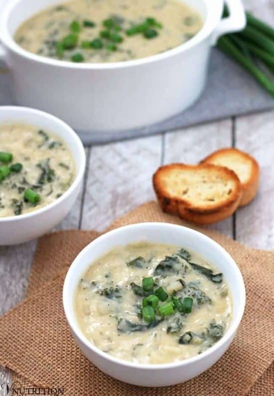 Vegan potato leek Soup in a white bowl on a piece of burlap.