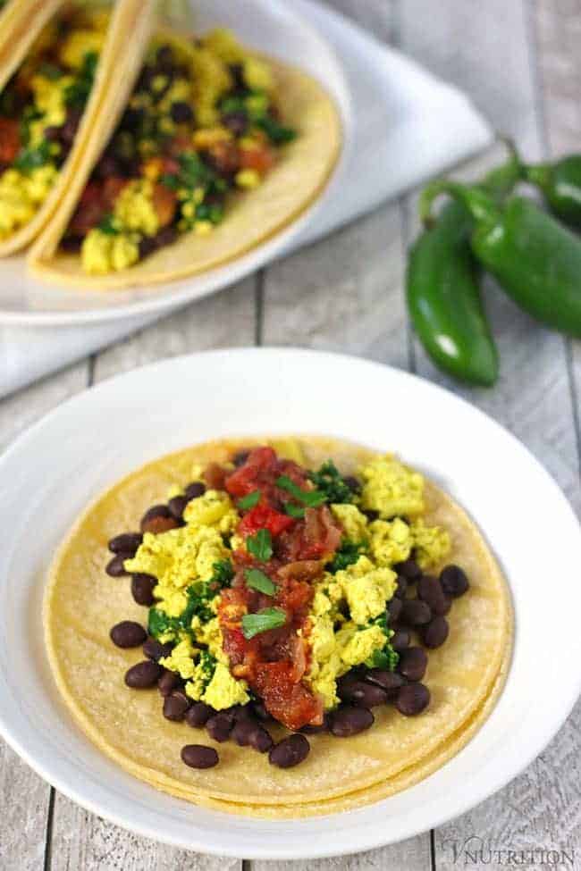 hero shot of Vegan Breakfast Tacos with scrambled tofu, fresh salsa, and black beans on a corn tortilla. 