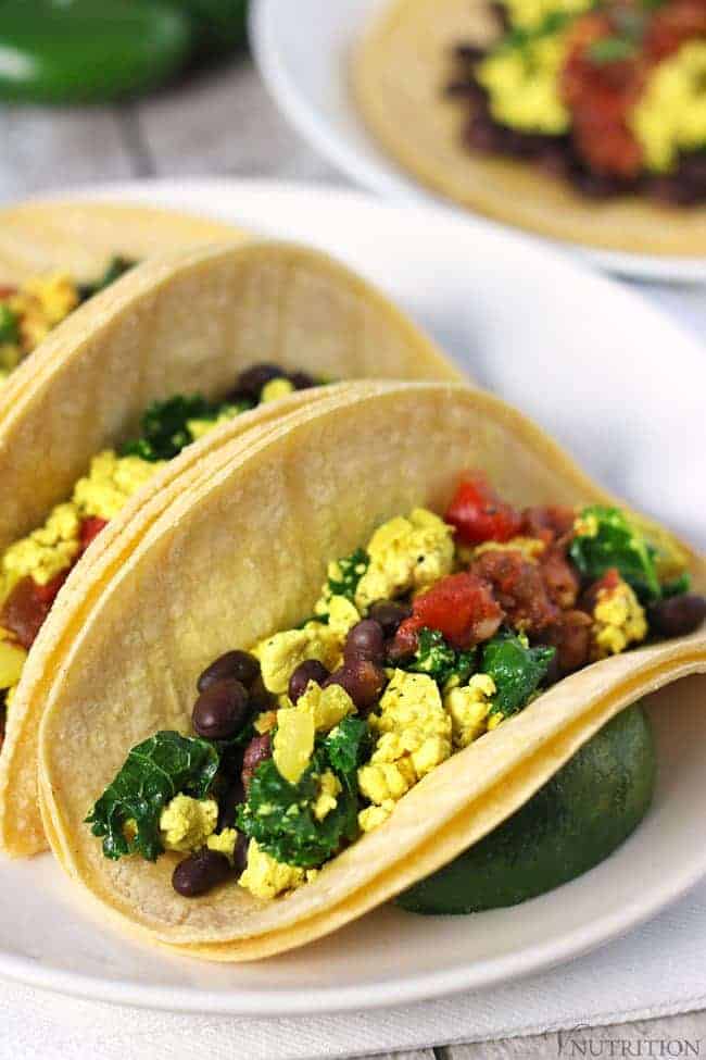 close up 45 degree angle shot of Vegan Breakfast Tacos on a white plate.