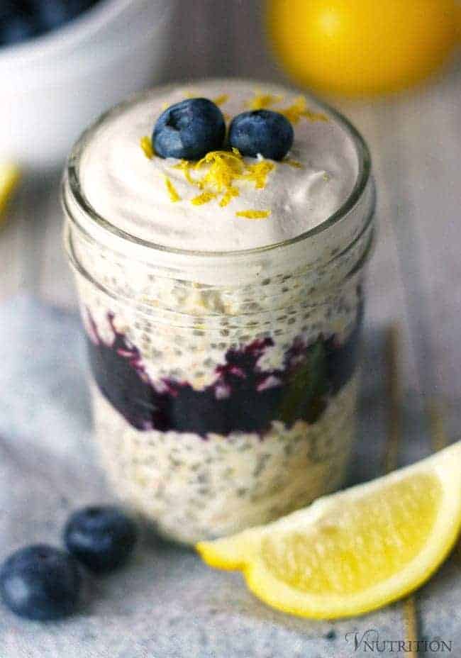 close up of vegan Cheesecake Overnight Oats layered with bluberry chia jam and cheesecake flavored cashew cream.