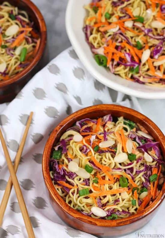overhead shot of a ceramic bowl filled with Vegan Ramen Noodle Salad next to wooden chopsticks