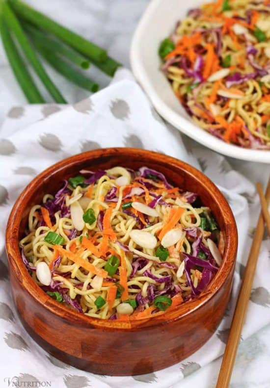 45 degree angle close up shot of Vegan Ramen Noodle Salad garnished with green onions and sliced almonds