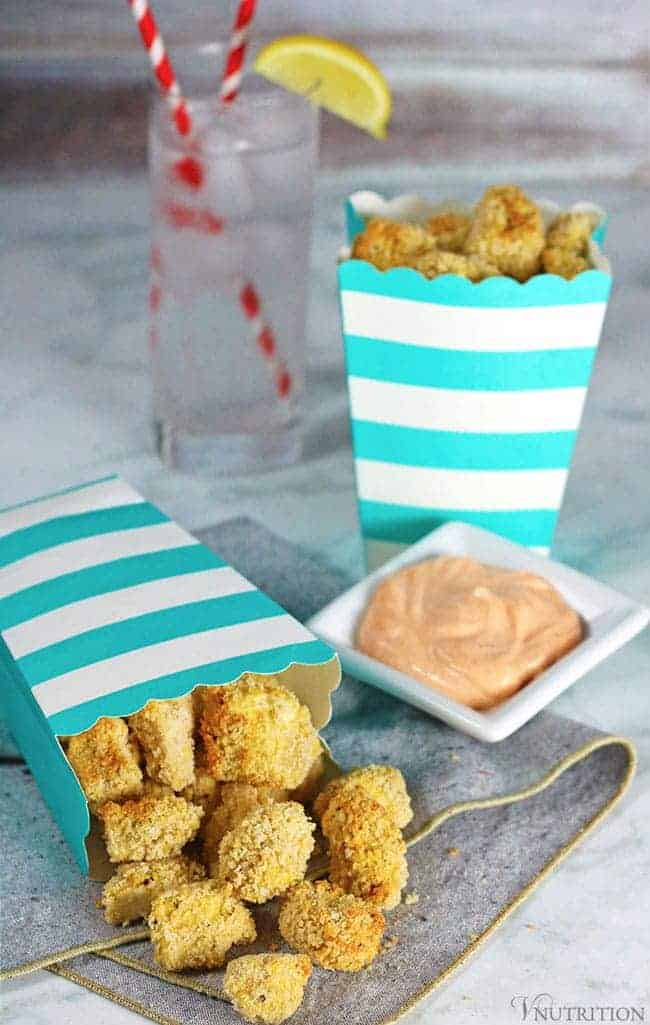 Air Fryer breaded tofu nuggets in a white and turquoise striped cardboard snack container with a side of sriracha mayonnaise