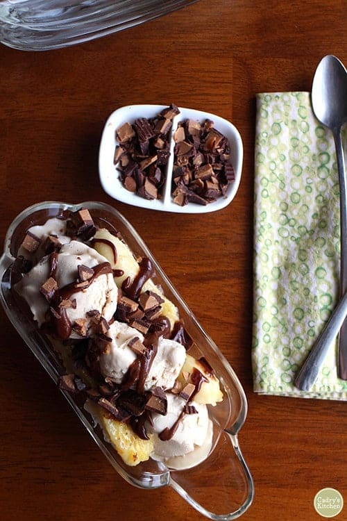 overhead shot of grilled banana split, utensils and peanut butter cups for vegan sides for grilling