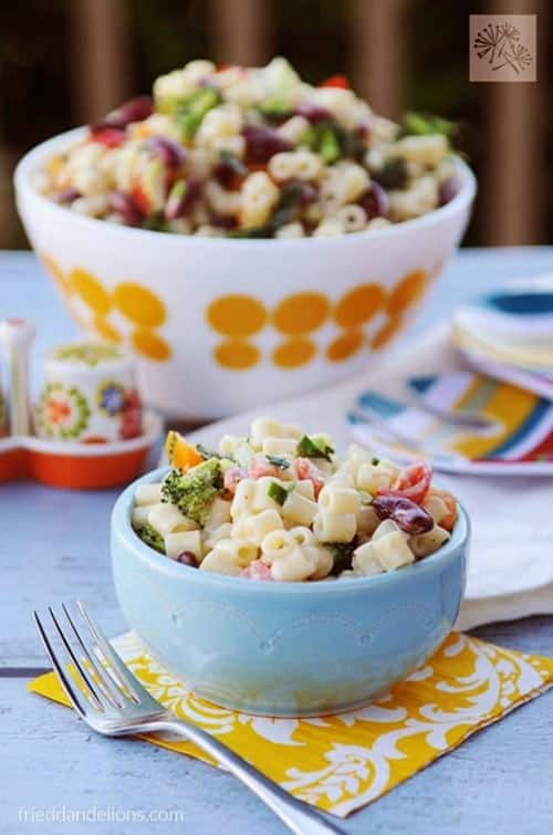 vegan macaroni salad with fork in forefront and large bowl of salad in background for vegan sides for grilling