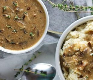 bowl of mushroom gravy poured over a bowl of mashed potatoes.