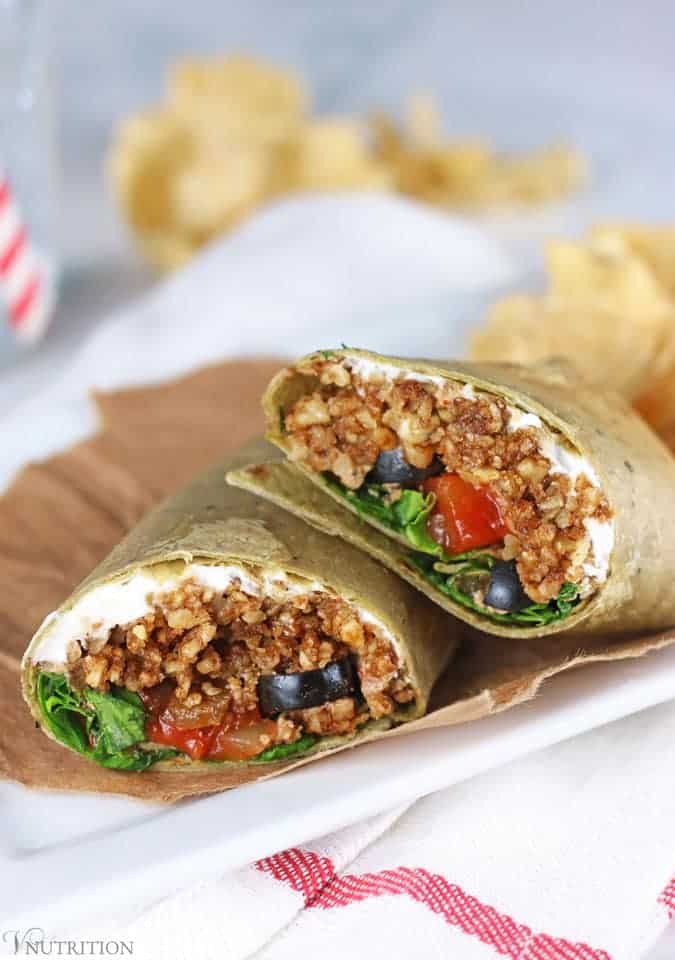 Vegan Taco Wraps with Walnut Meat | These gluten free vegan taco wraps have all the tastiness of tacos in a convenient wrap form. They're perfect to take for lunch when you're craving a taco but want it in something other than a taco shell. closeup of Vegan burrito Wraps on plate and napkin with chips in the background.