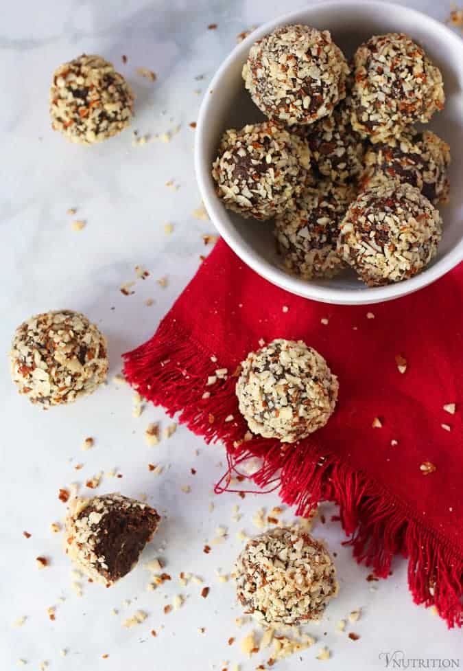 Chocolate Cherry Protein Balls in bowl with balls and red napkin next to bowl
