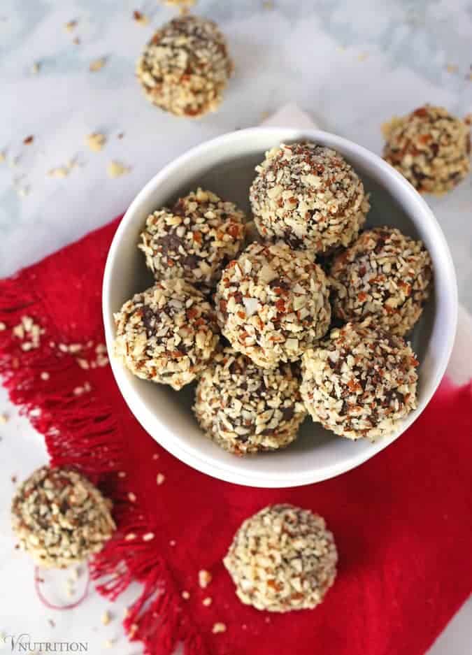 overhead shot of Chocolate Cherry Protein Balls in bowl with red napkin and balls in background