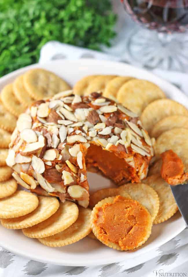 plate of vegan port wine cheese with some of it spread on a cracker.