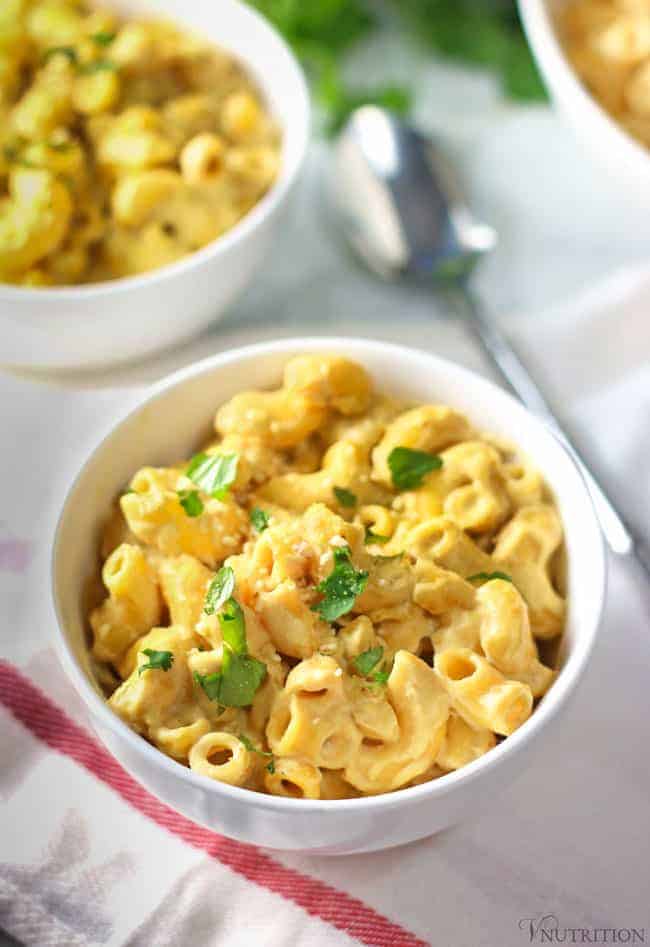 close up shot of a bowl of Creamy Vegan Cashew Mac and Cheese garnished with parsley.