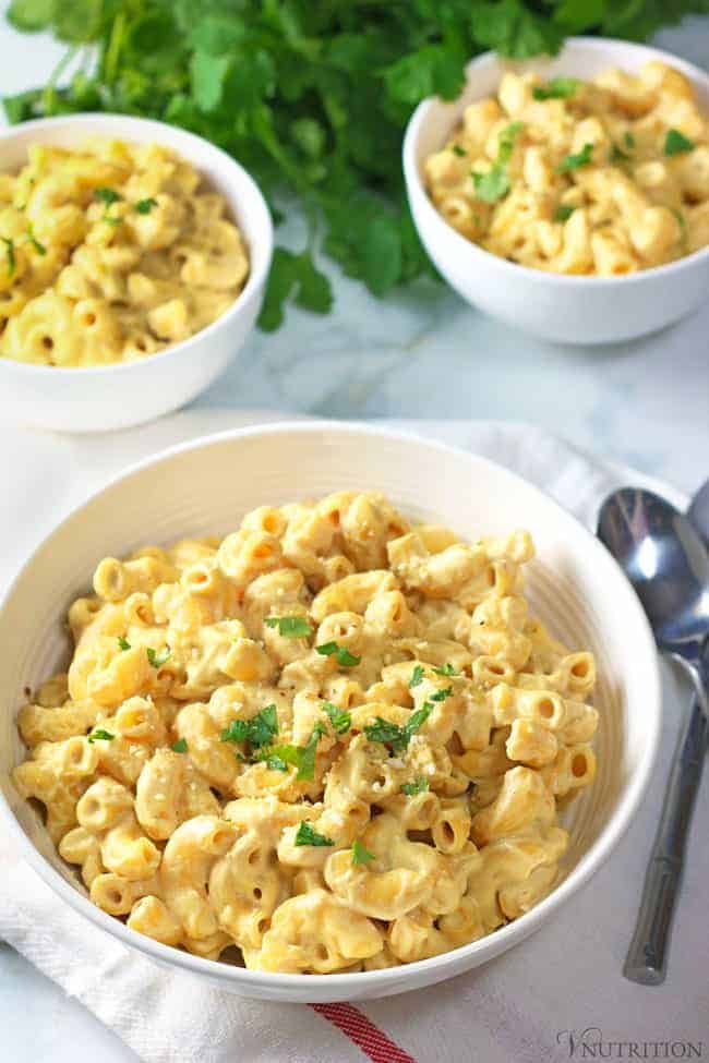 Creamy Vegan Cashew Mac and Cheese in bowl with a silver spoon and a white napkin.