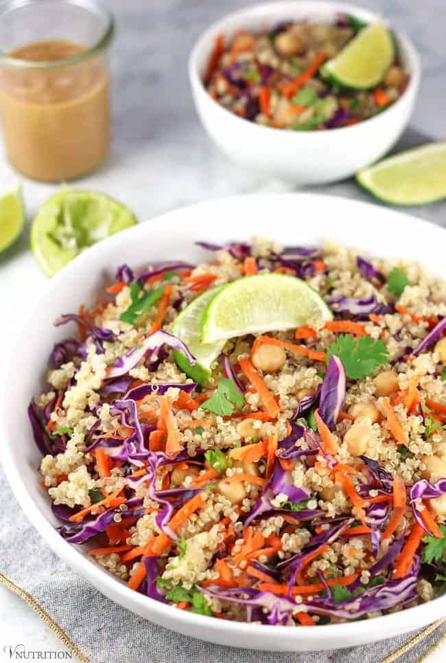 chickpea Thai Quinoa Salad in a white bowl with two slices of lime on top.