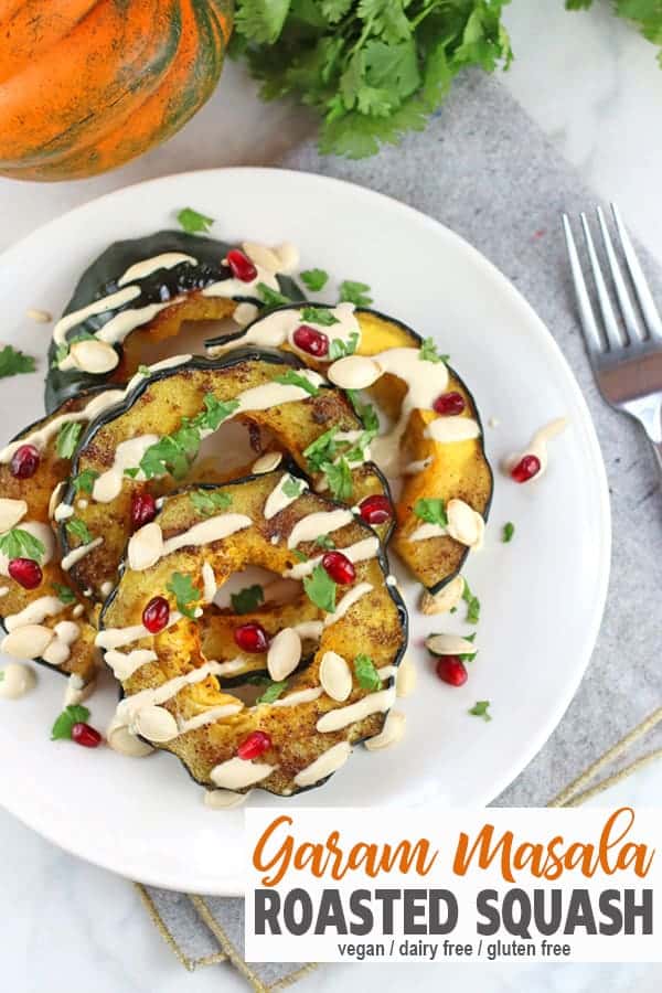 Garam Masala Roasted Squash | This Garam Masala Roasted Acorn Squash is easy to make and a great addition to any healthy holiday table. It's paired with a tangy lemon tahini sauce, sweet pomegranates and crunchy pepitas. This garam masala acorn squash recipe is vegan, vegetarian, dairy-free, and healthy! #garammasalaroastedsquash #garammasalaacornsquash #garammasalasquash #vnutrition #roastedacornsquash #roastedsquashrecipe #veganoroastedsquashrecipe