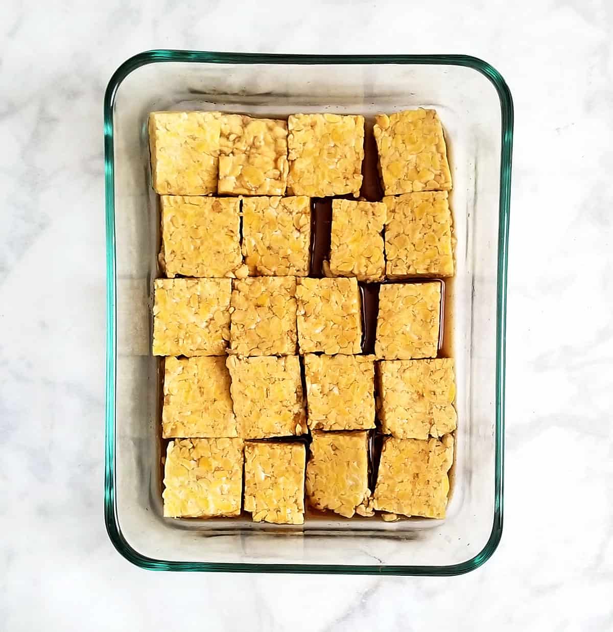 tempeh marinating in glass bowl