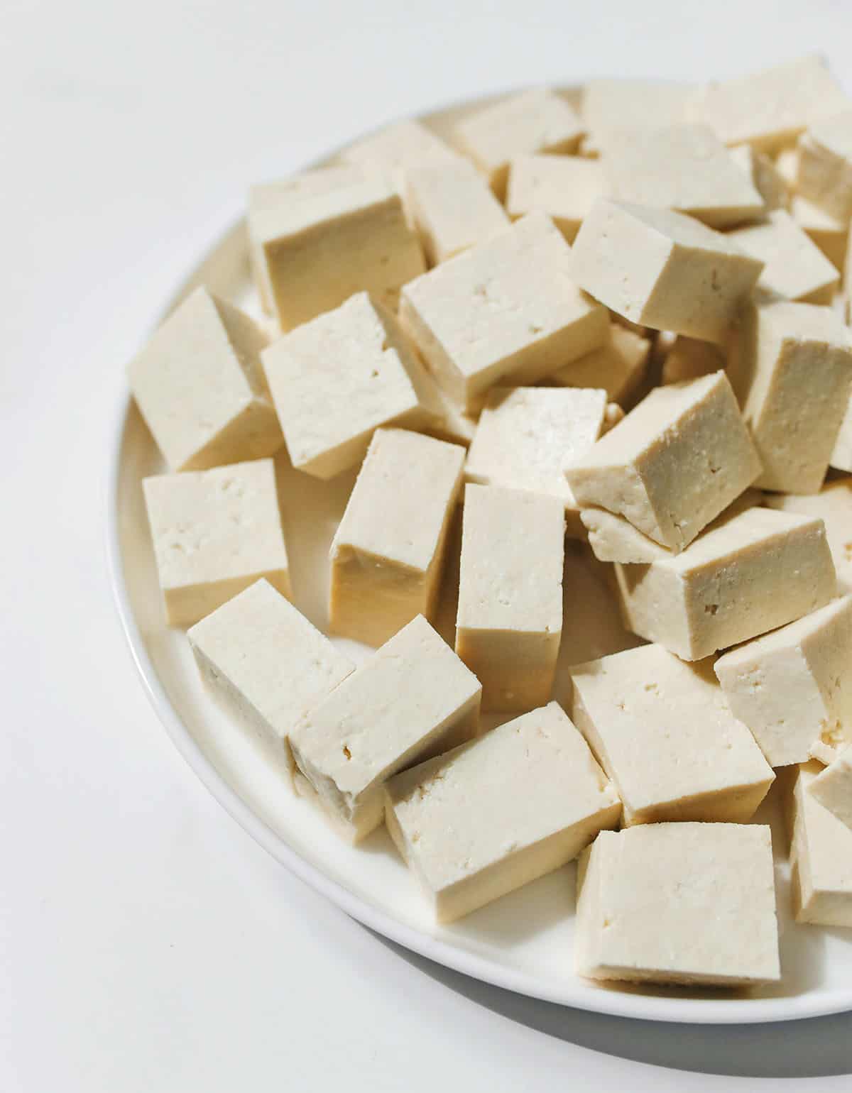 cubes of tofu on a white plate on a white background