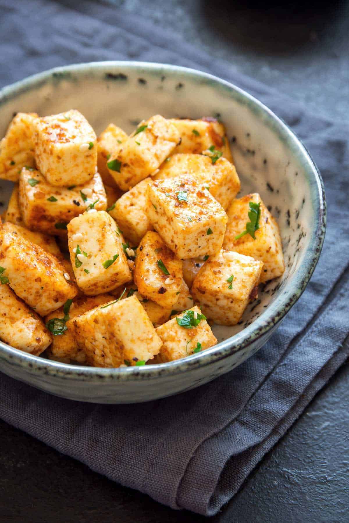 crispy cooked tofu in a bowl with blue napkin