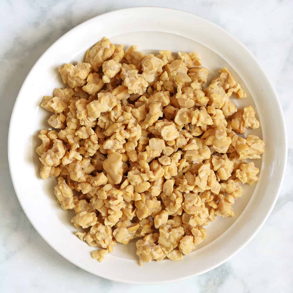 crumbled tempeh in a white bowl.