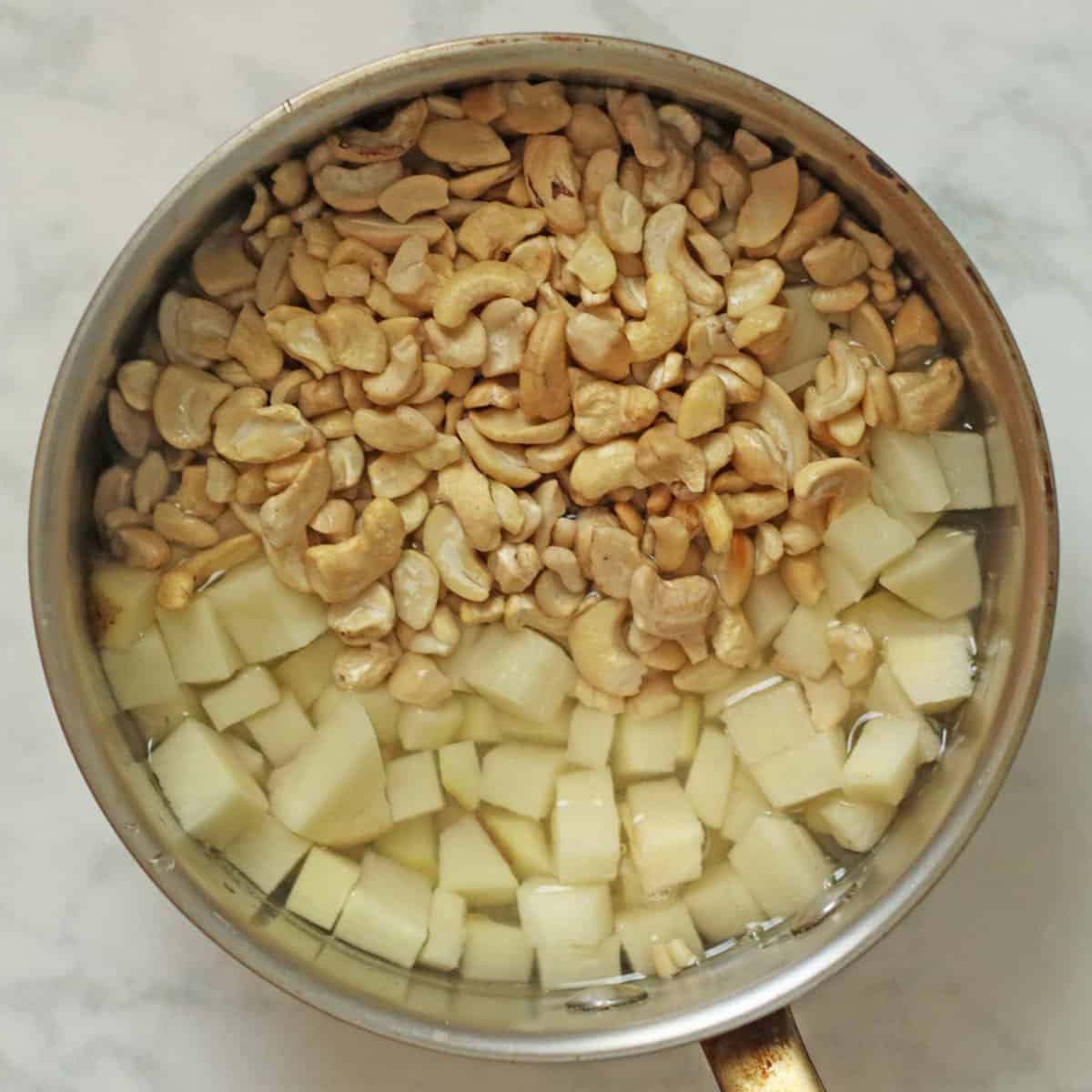 boiling potatoes and cashews in pot