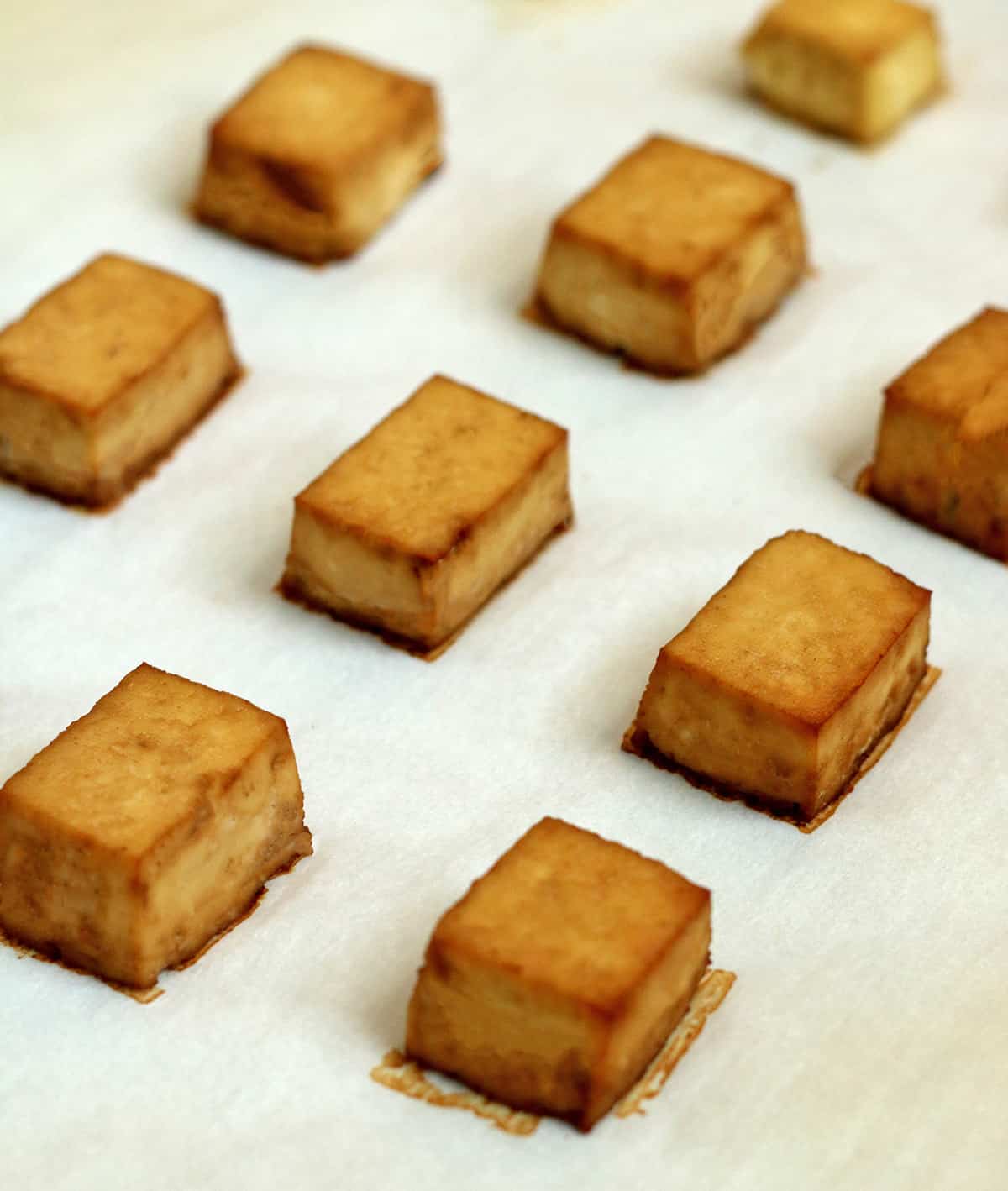 marinated tofu baking on parchment paper.