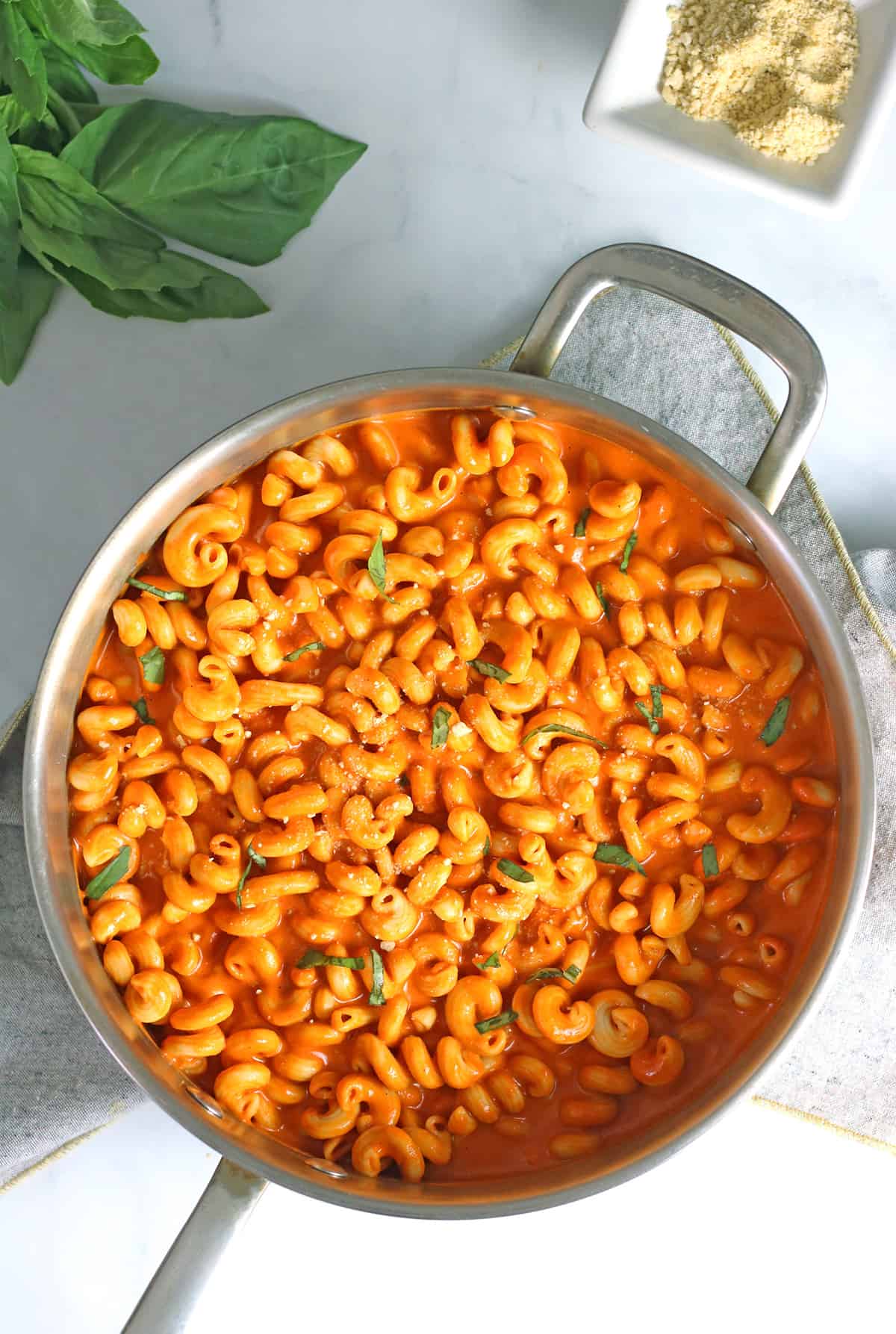 vegan roasted red pepper pasta with large saucepan with vegan parmesan.