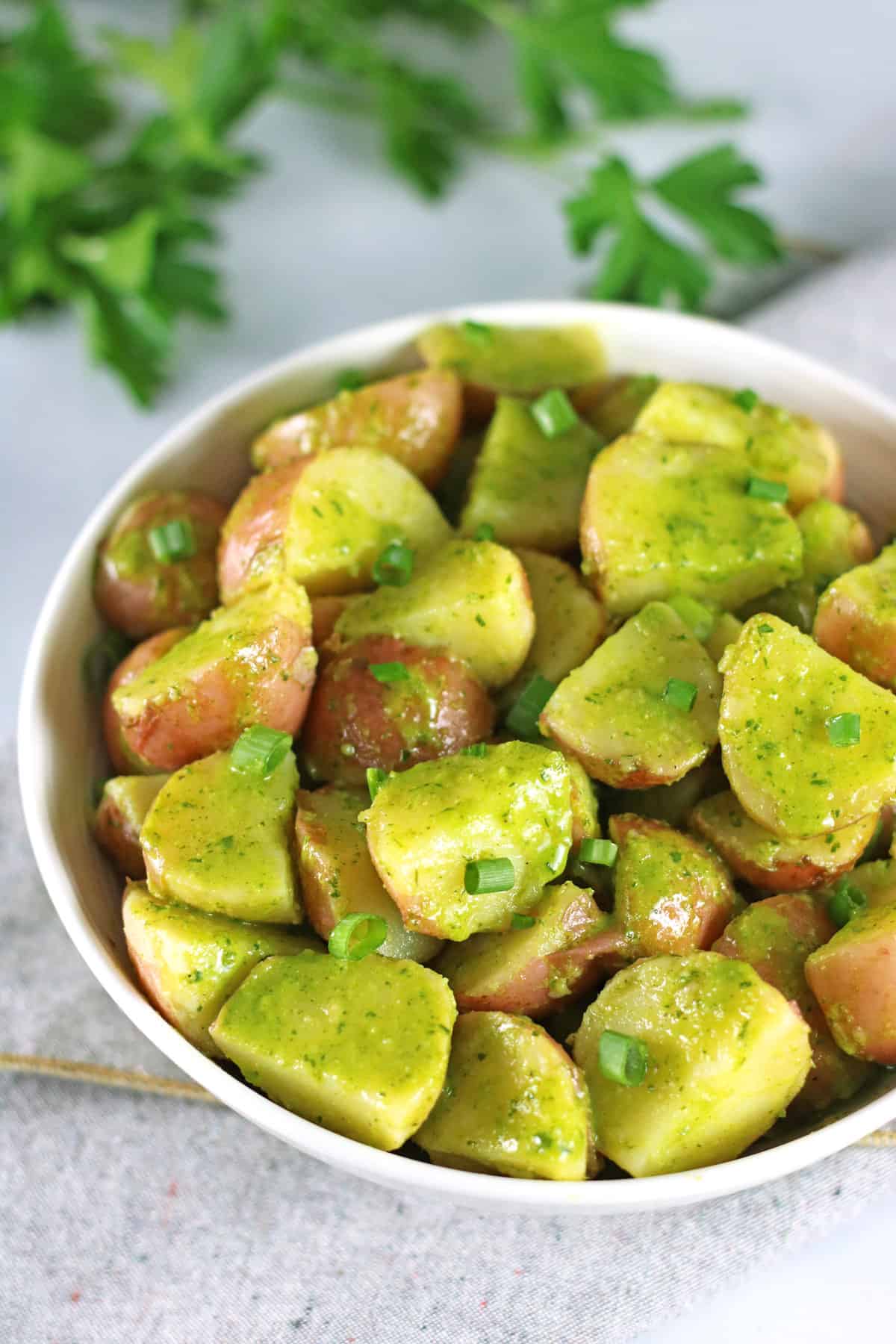 potato salad with no mayo in white bowl with fresh herbs