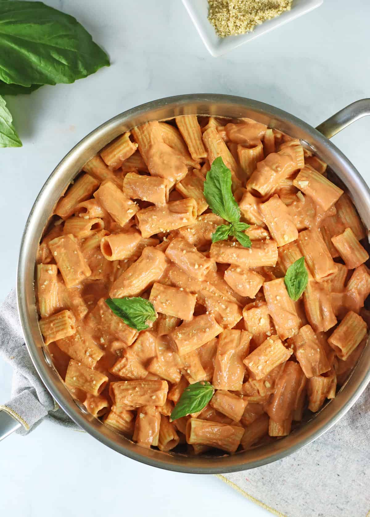 vegan vodka sauce in a large saucepan with fresh basil.