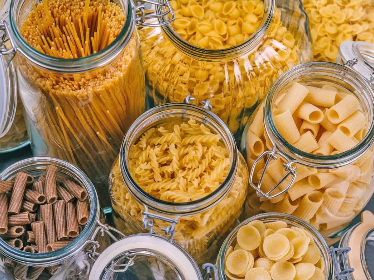 assorted dry pasta shapes in glass jars