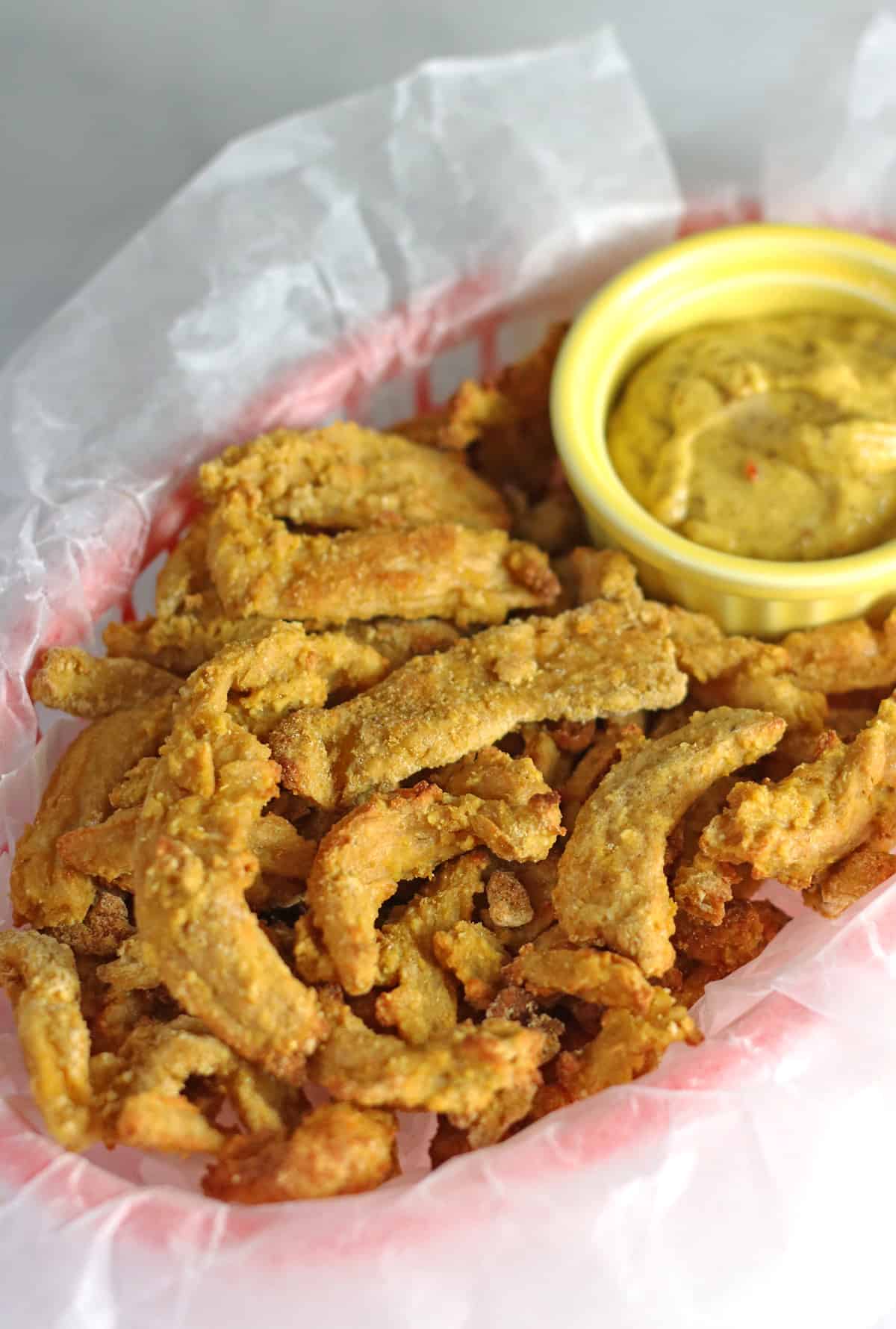 vegan chicken in red basket with mustard dipping sauce