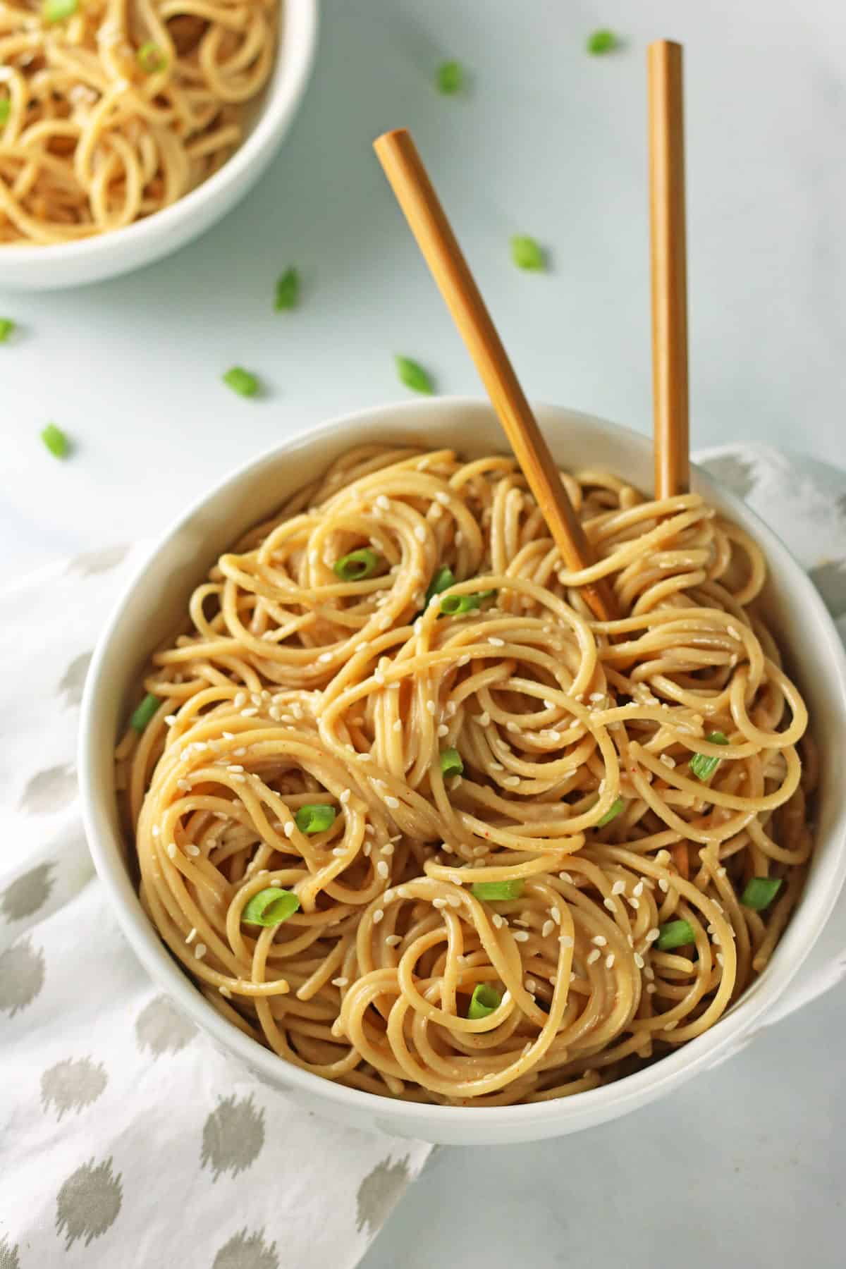 spicy Garlic sesame ramen noodles in a white bowl with chopsticks sticking out.