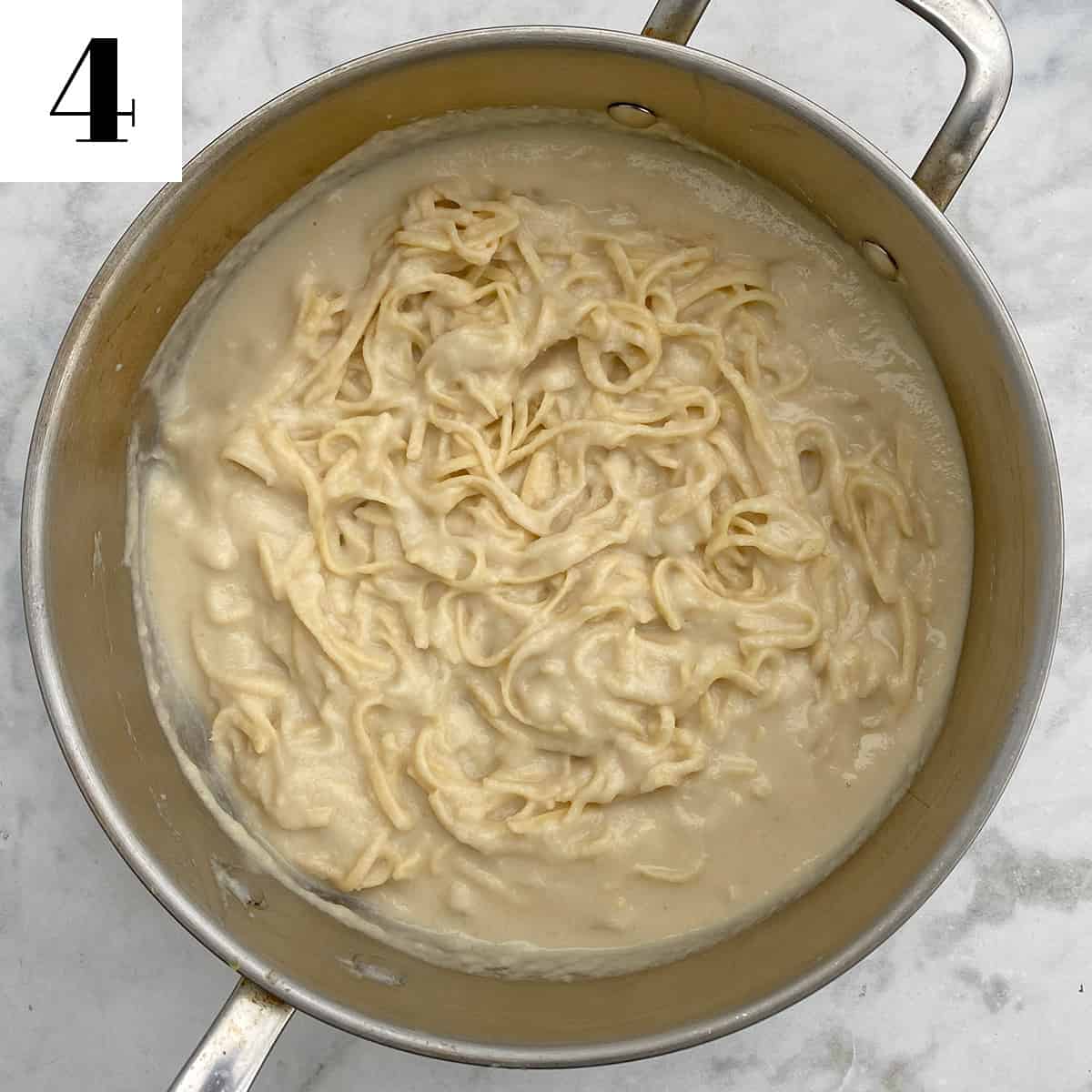 cauliflower alfredo with pasta in large pan.