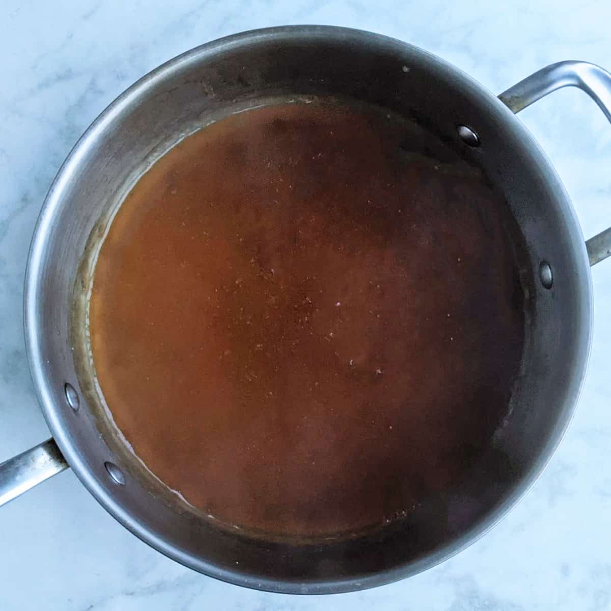 teriyaki sauce cooking in large pan.