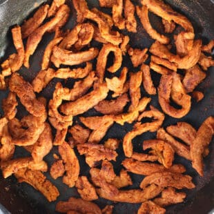 vegan bacon in a cast iron pan.