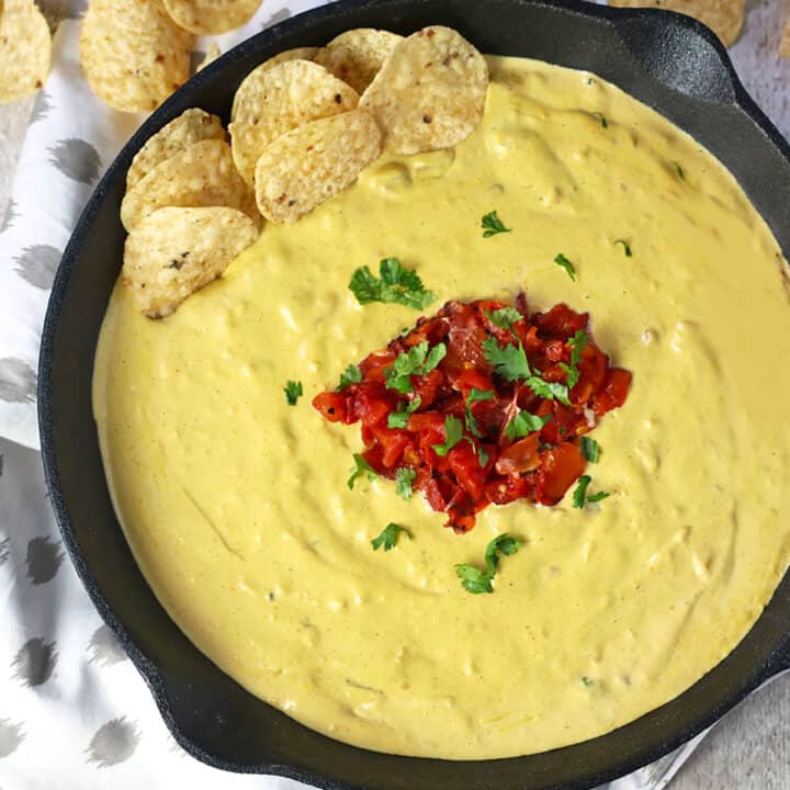 vegan cashew queso in skillet with tortilla chips.