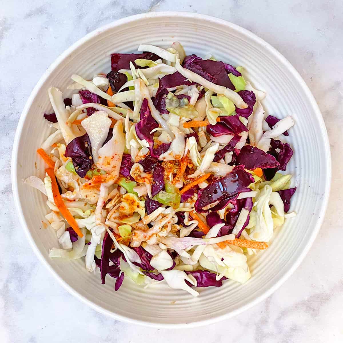 tempeh taco slaw in white bowl with dressing.