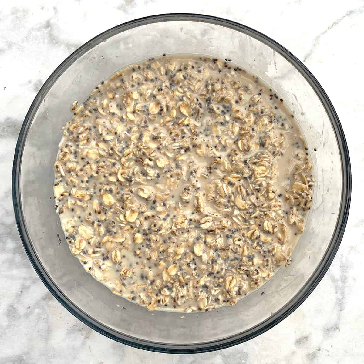 soaking overnight oats, milk, and chia seeds in glass jar.