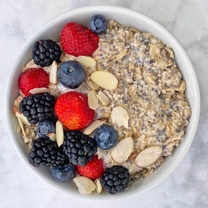 vegan overnight oats with berries and nuts in while bowl.